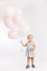 Fototapeta premium Little cute girl hold menu pink and white balloons enjoy festive birthday event wear grey pastel summer dress rabbit-footwear isolated on a white background.