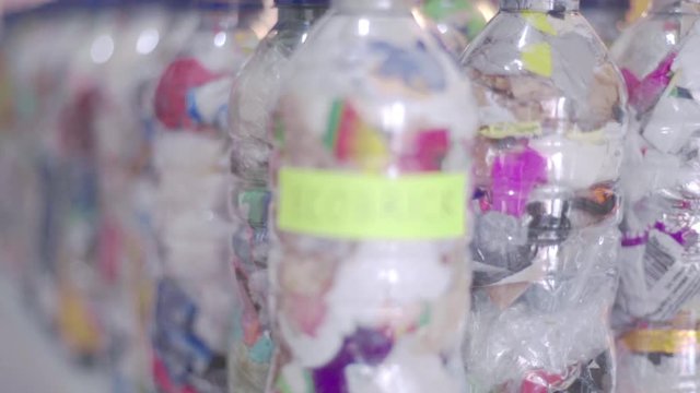 Close up of colorful ecobricks lined up in a triangle with yellow sign, rack