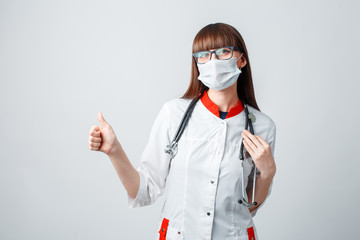 Young doctor in a coat and mask on a white background