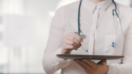 Healthcare and technology. Doctor working on a digital tablet in hospital. Healthcare worker signing prescription for online healthcare service