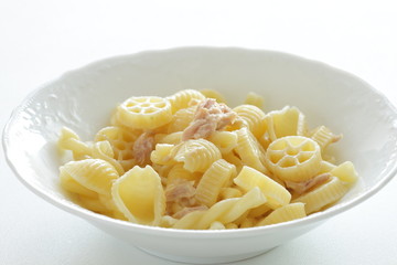 Prepared pasta and tuna salad in white bowl on white background