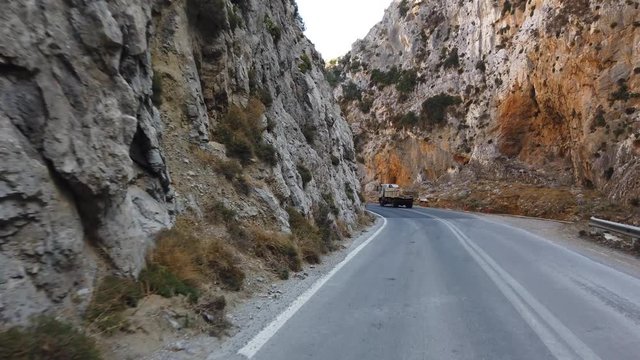 Driving a car on a mountain road on a summer day. Crete island, Greece. Car rental and travel concept.