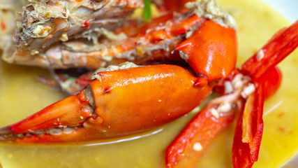 Indonesia crab curry garnished with red chili. Focus on the big claw