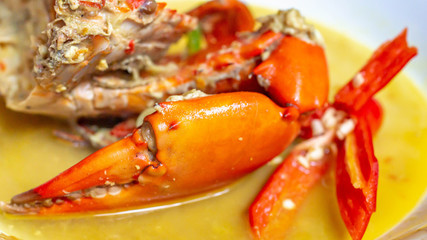 Obraz na płótnie Canvas Indonesia crab curry garnished with red chili. Focus on the big claw