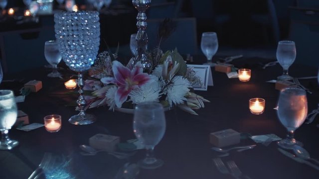 Table serving with floral decorative composition and burning candles with switched off light in the fashionable authentic luxury restaurant