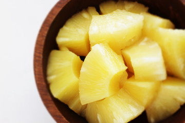 Canned food, pineapple in wooden bowl with copy space