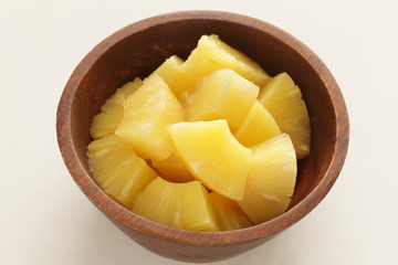 Canned food, pineapple in wooden bowl with copy space