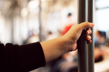 Hand touching a coronavirus contaminated train handrail