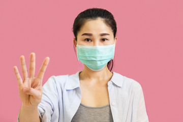 Young asian woman wore a gray undershirt, Blue shirt and protective masks against virus and air pollution isolated on pink background,health care concept