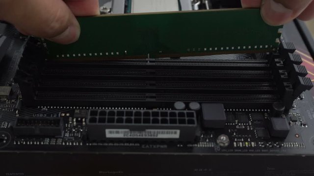 Installing random access memory RAM into modern black motherboard for PC or Server