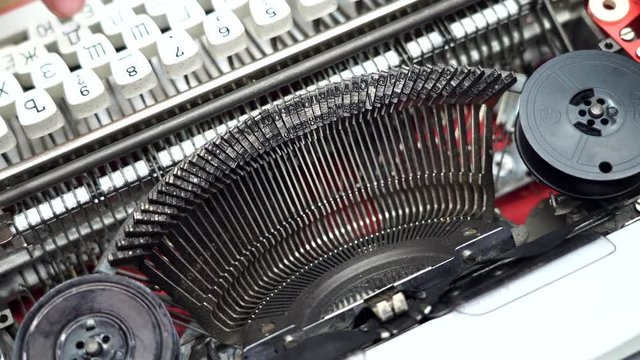 Typewriter, stamps of letters type on a white sheet of paper, concept of news, finance. retro print. pressing the keys with your fingers. ink ribbon. Cyrillic keyboard. man is typing