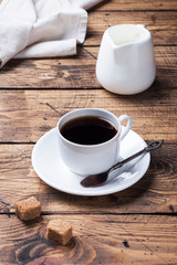 Obraz premium Cup of black coffee and milk on a wooden background. Copy space.