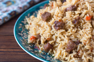 pilaf in a plate with a national pattern, Uzbek dishes, oriental cuisine, close-up