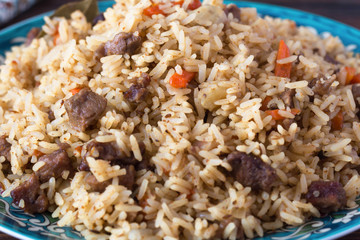 pilaf in a plate with a national pattern, Uzbek dishes, oriental cuisine, close-up
