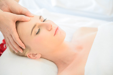 Obraz na płótnie Canvas Beautiful woman receiving head and facial massage in spa salon. Concept of body health care and traditional thai massage relax