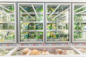 Shelves with frozen food in a supermarket. Space for text. Blurred.