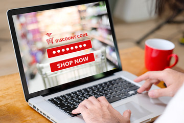 E-coupon, Grocery shopping online, Woman hand using laptop computer entering the discount coupon...