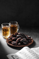 dates fruit and Islamic Book Koran on a concrete background, Islamic background in ramadan