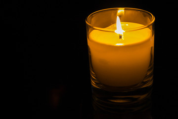Candle in a glass jar on a dark background