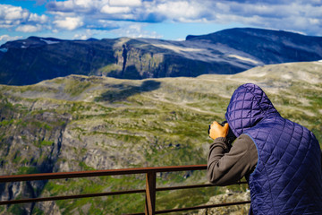 Fototapeta na wymiar Tourist taking photo in norwegian mountains