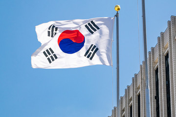 South Korean flag waving in the wind atop a government building on a sunny day - Seoul, South Korea