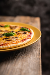 Freshly making pizza with mushrooms served on the rustic background. Selective focus. Shallow depth of field.