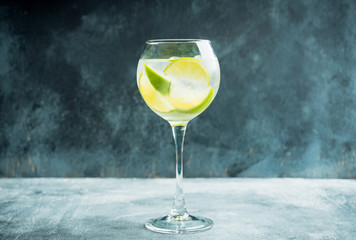 Rum based cocktail with lime in wine glass (variation of cuba libre) on the rustic background. Selective focus. Shallow depth of field.