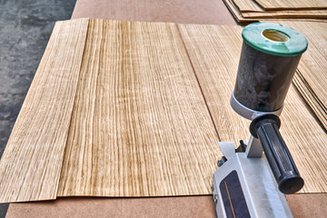 Oak veneer. Oak texture. Veneer splicing process with veneer hand splicer in woodshop