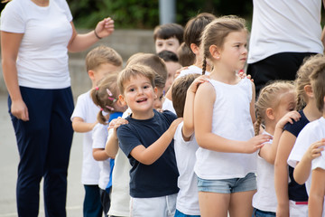 Close up of children group standing in column and waiting for lesson start.  Sport school