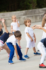 Close up of children group warming up and preparing for the main part of lesson.  Sport school