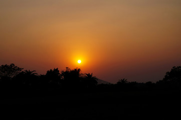 Sunset in the rural village of India, beside the mountains through the vegetation at evening time