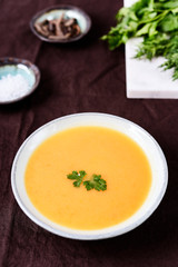 Healthy Vegetable Cream Soup in a bowl on linen tablecloth. Vertical composition. Selective focus
