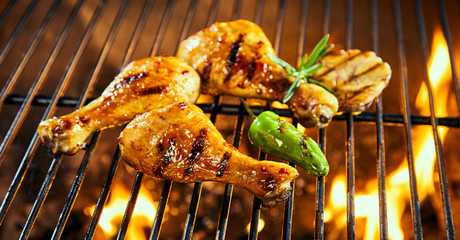 Marinated chicken drumsticks grilling on a BBQ
