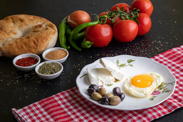 Prepared vegetables and breakfast plate on black background