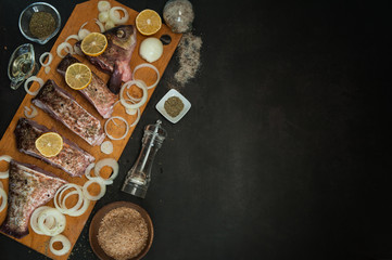 Cooking fresh fish. Sliced bream (Abramis), surrounded by onions, lemons, spices and olive oil,...