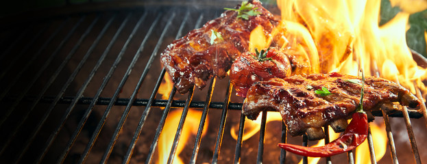 Marinated spicy pork ribs grilling on a bbq - obrazy, fototapety, plakaty