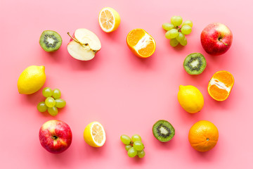 Fototapeta na wymiar Colorful fruit mockup. Cut apple, kiwi, citrus on pink background top-down copy space