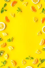 Colorful summer fruits frame on yellow background top view copy space