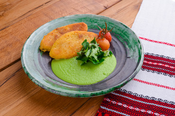 Minced meat cutlets with vegetable puree served on blue plate over brown wooden background