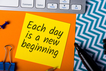 Each day is a new beggining - motivational note on office background
