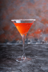 Red cocktail with bloody oranges in martini glass on the rustic background. Selective focus. Shallow depth of field.