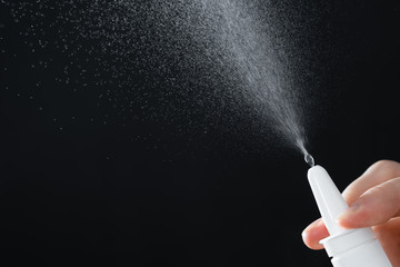 man's hand with a bottle of medication. Treatment colds via a nasal spray