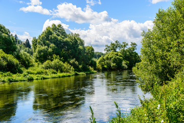 Fototapeta premium Blue sky with clouds reflected on the surface of river