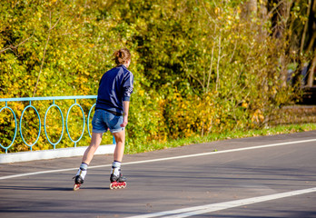 Girl roller skating in the autumn Park
