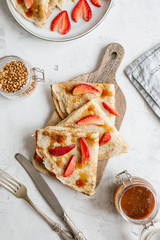 Rustic breakfast with pancakes, fresh strawberries and salted caramel
