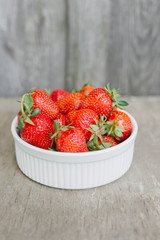 Strawberries in bowl on wooden background