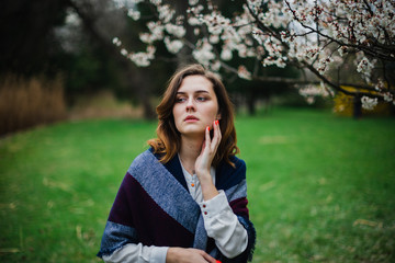 Beautiful young girl is resting and enjoying spring in the spring park