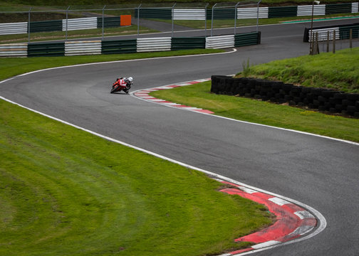A shot of a red racing bike speeding round an s-bend.