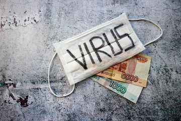 Crisis wallpaper new covid 2019 coronavirus strikes Russia economy medical mask on a stone background with the inscription virus with 1000 and 5000 roubles banknote