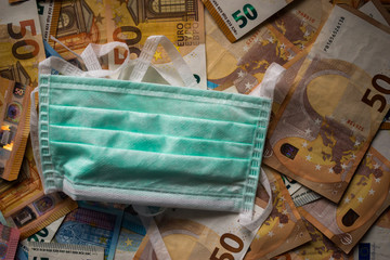 Medical protective face mask on paper money, banknotes background